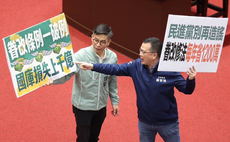立法院會三讀修正通過國軍老舊眷村改建條例第3條條文。圖為國民黨立委羅智強（右）與民進黨團幹事長鍾佳濱（左）手持看板表達立場。（中央社檔案照）