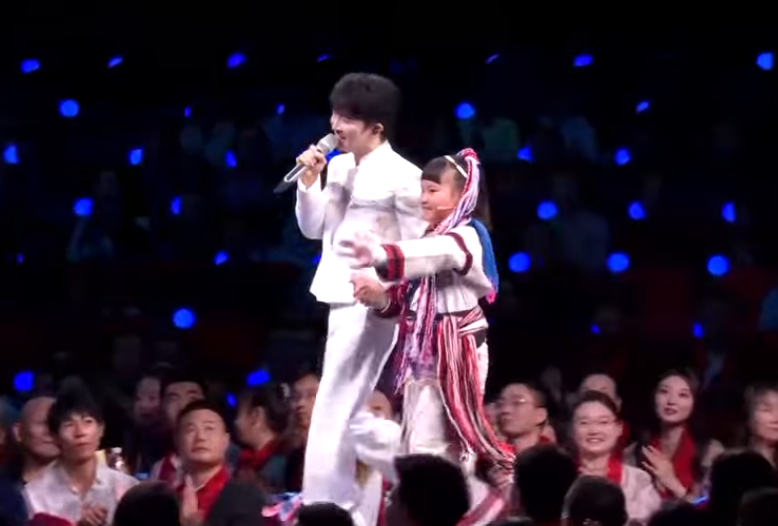中國歌手周深在《央視》春晚牽著台灣高山族女童。（圖擷自微博）