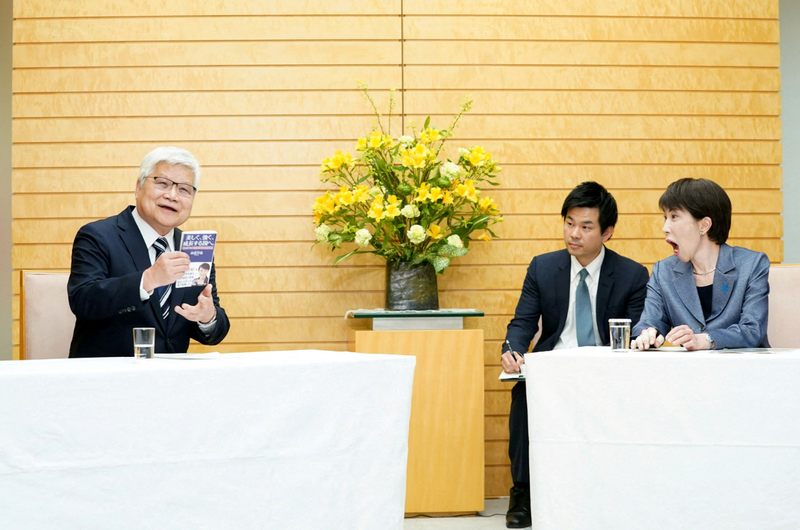 日本首相高市早苗（右）看到台積電董事長魏哲家（左）拿出自己的著作，相當驚訝。（路透檔案照）