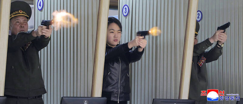 北韓領導人金正恩女兒金主愛（中）在軍需工廠內試射新型手槍。（美聯社檔案照）