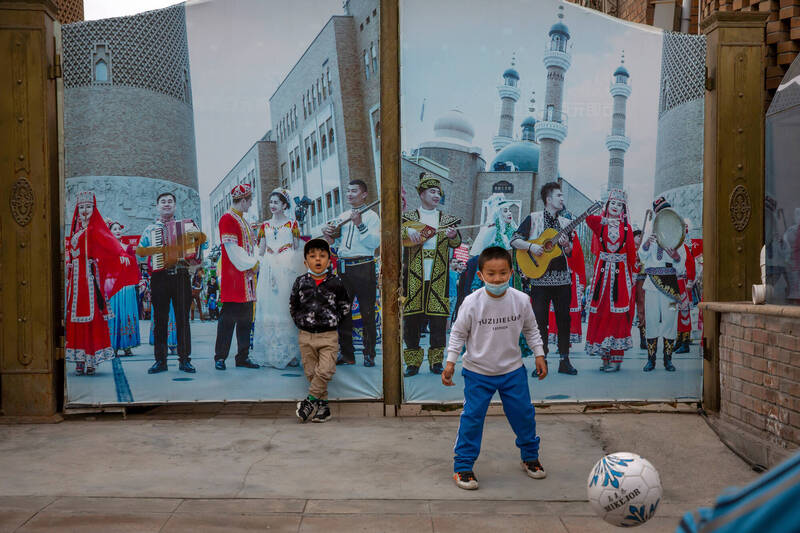 中國全國人大會議近期通過《民族團結進步促進法》，將原本屬於個人的「認同問題」強制轉化為「法律問題」，試圖在無形中劃下一道威懾紅線。圖為維吾爾族孩子踢足球。（美聯社檔案照）