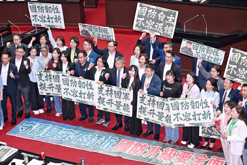 立法院5月8日舉行院會處理議案，三讀通過「保衛國家安全及強化不對稱戰力計畫採購特別條例草案」，民進黨立委舉海報表達訴求。（資料照）