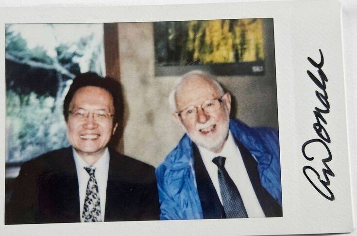 筆者與2015年諾貝爾物理學獎得主Arthur B. McDonald（右）合影。（作者提供）