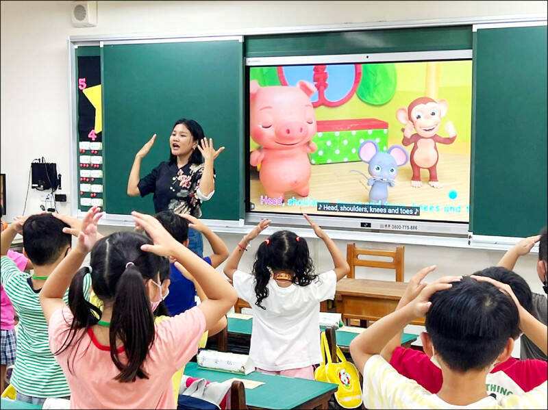 現今大部分的家長還是認為英文重於台語或母語。圖為台南隆田國小雙語教學老師與學生互動。（資料照，南市教育局提供）