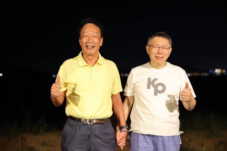 郭台銘（左）與柯文哲（右）2023年5月30日在金門相約海邊散步，2人還牽手合影。（民眾提供）